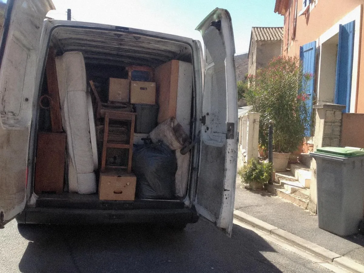 Déménageurs chargeant des meubles dans un camion devant une maison